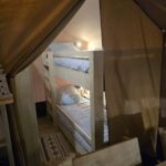 Lits superposés en bois chaleureux pour enfants dans tente Safari